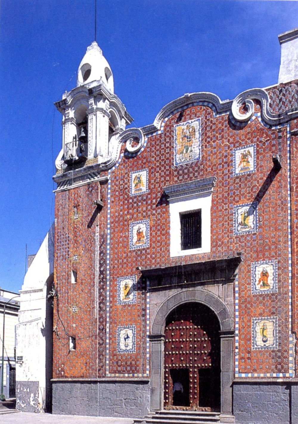 A red tiled building with a white bell tower at top left.