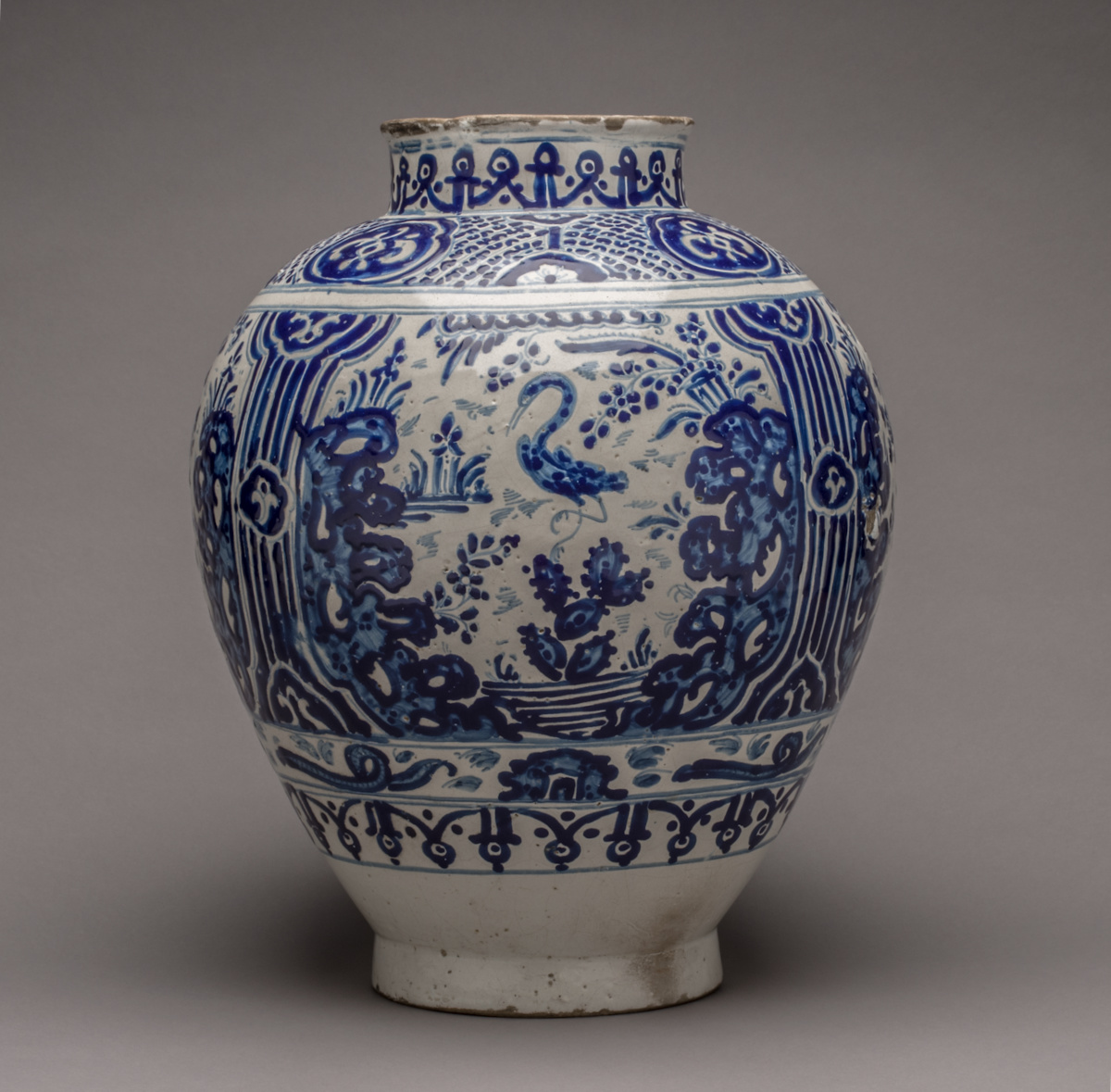 A round white vessel with blue animal and vegetation motifs.