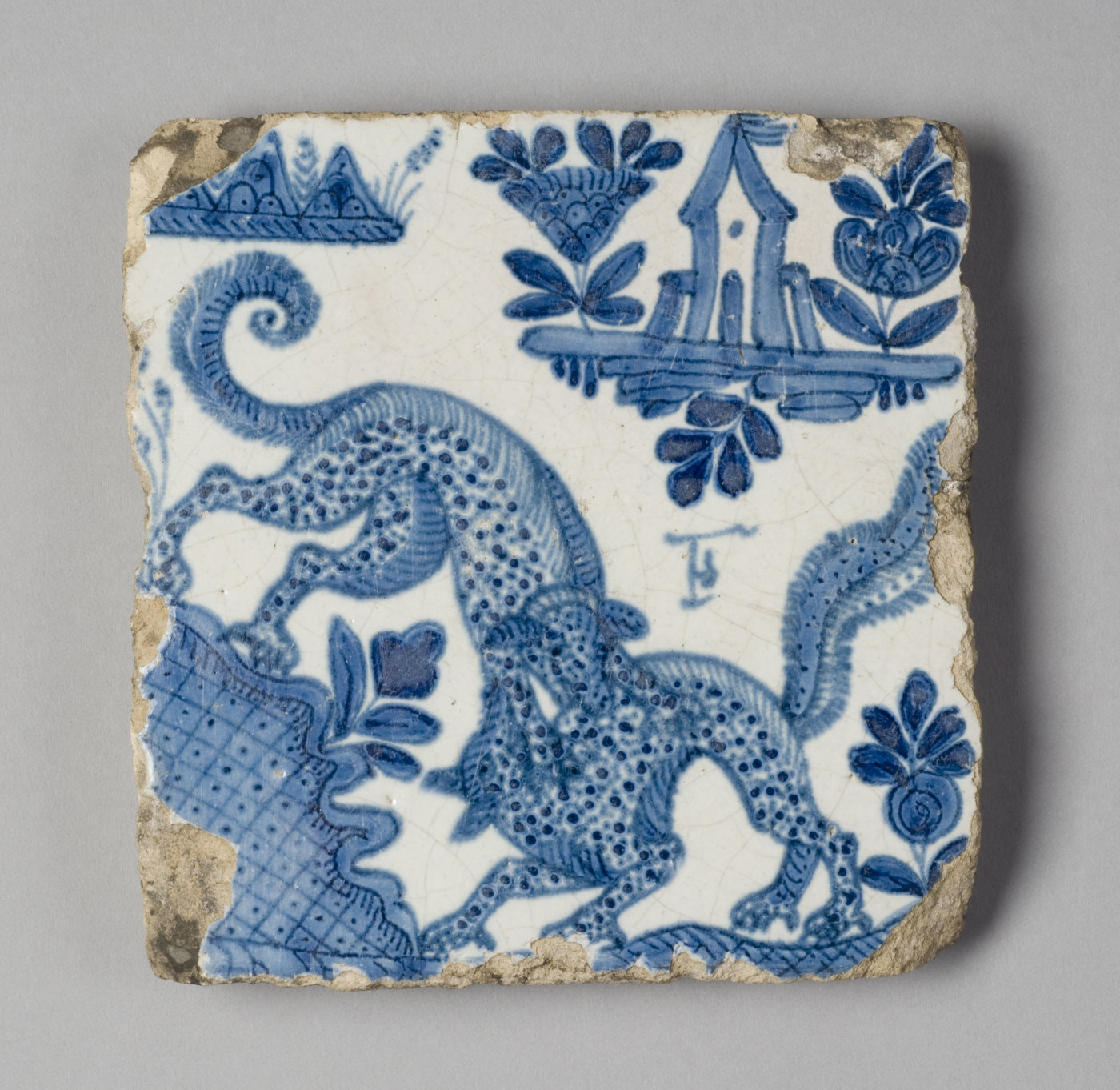 A white tile with broken edges features blue architectural, animal, and floral motifs.