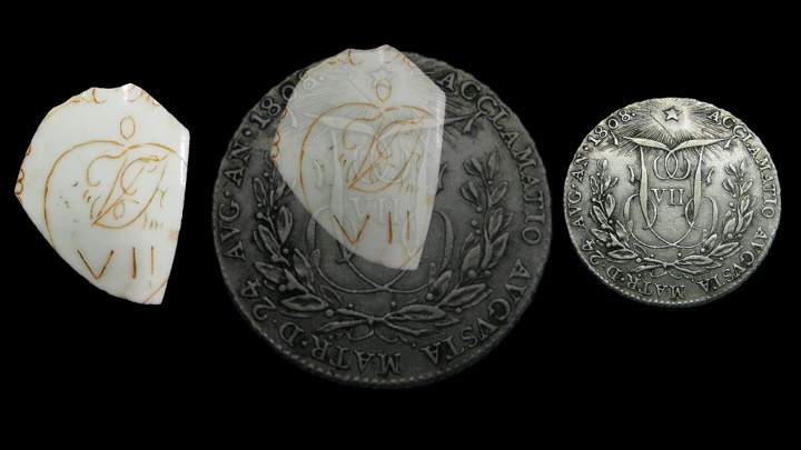 A white shard with brown cursive letters and the roman numeral VII at left; a silver coin with the roman numeral VII at right; and the two overlaid at center.