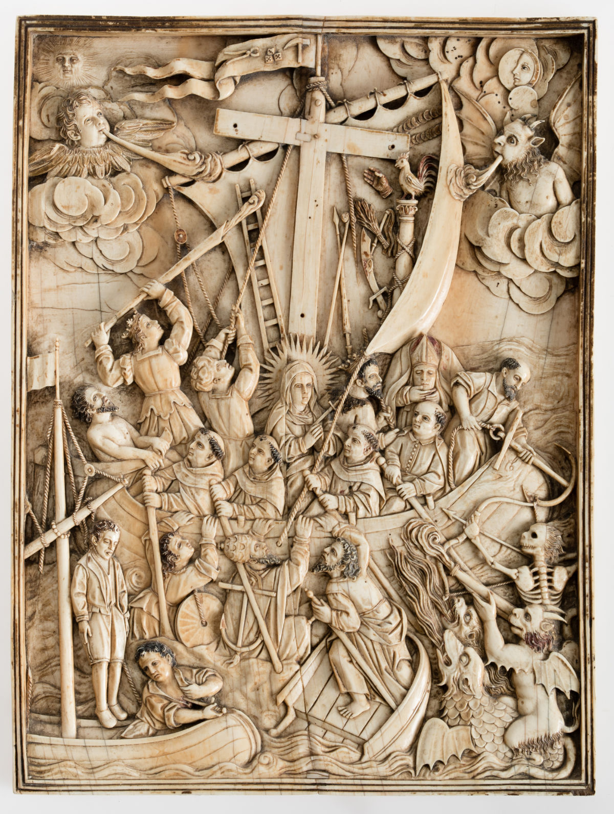 An ivory bas relief of a ship heavily populated with religious figures and a cross for a mast.