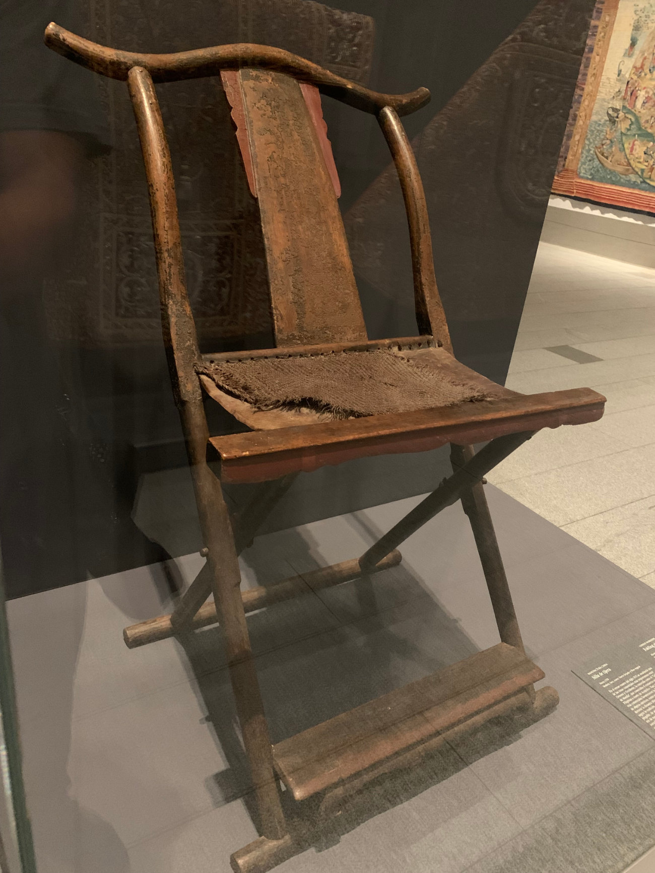 A brown, armless chair with a curving back.