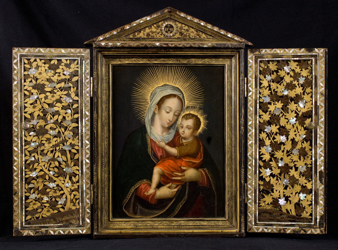 A photo of a winged altar with embellished doors and a central scene of the Virgin and Child.
