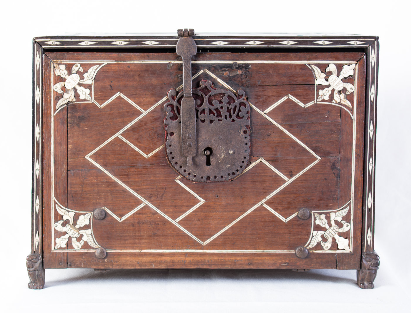 A wooden cabinet with an ornate locking hinge.