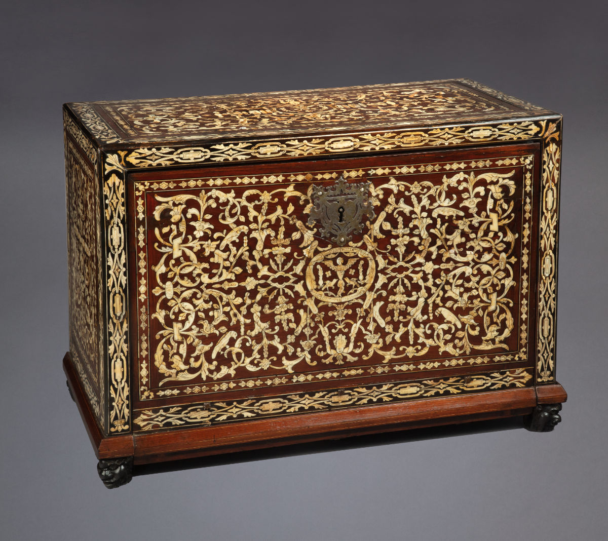 A wooden box with intricate vegetal motifs.