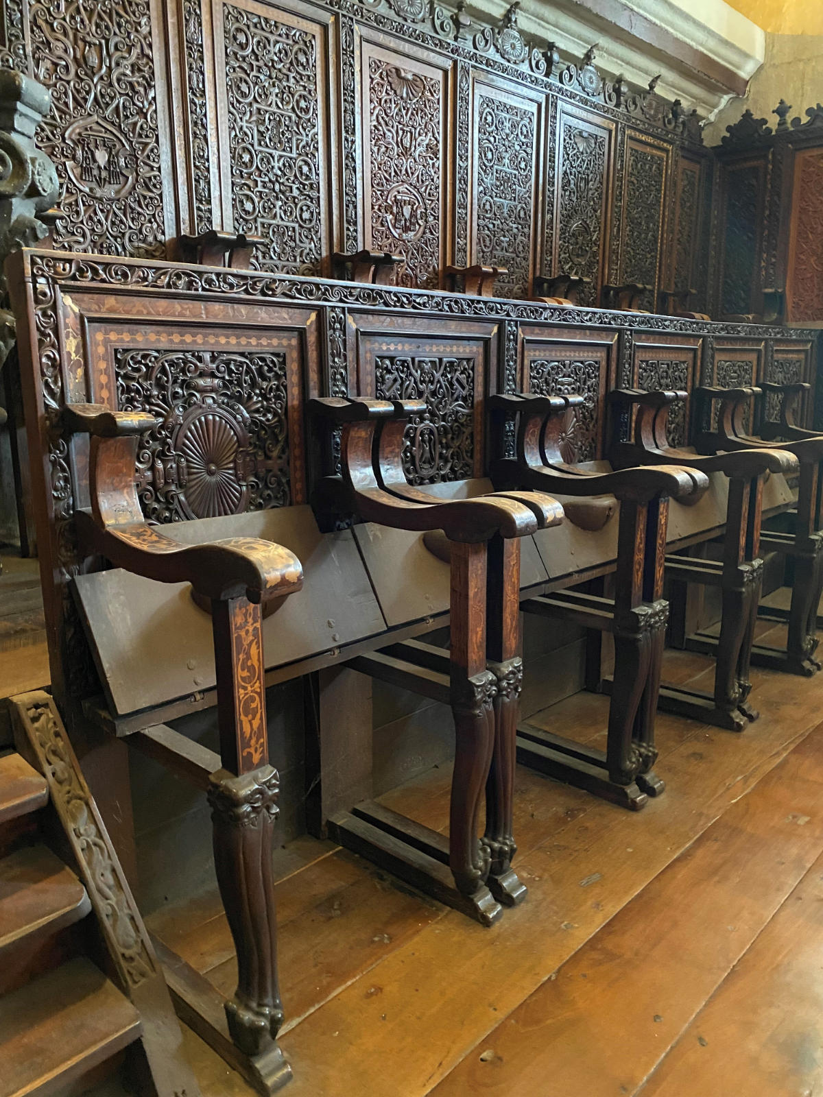 A photograph of ornate, wooden choirstalls.