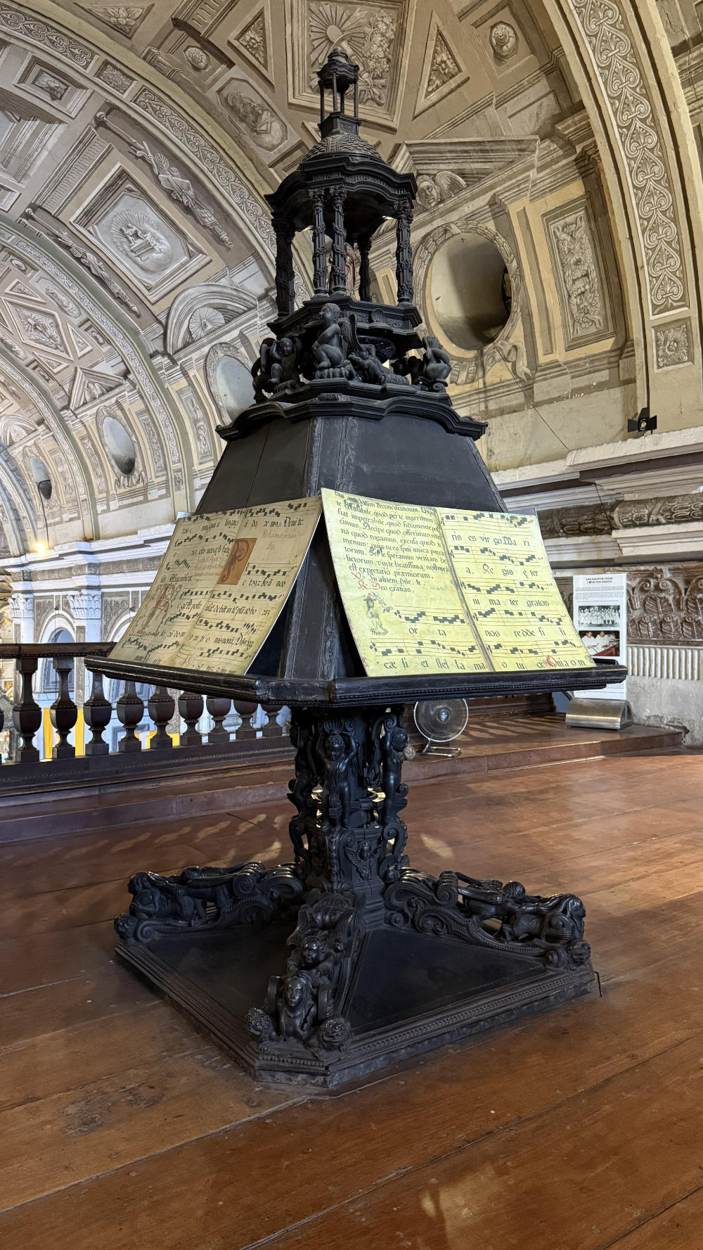 A large, wooden lectern holding several sheets of music.