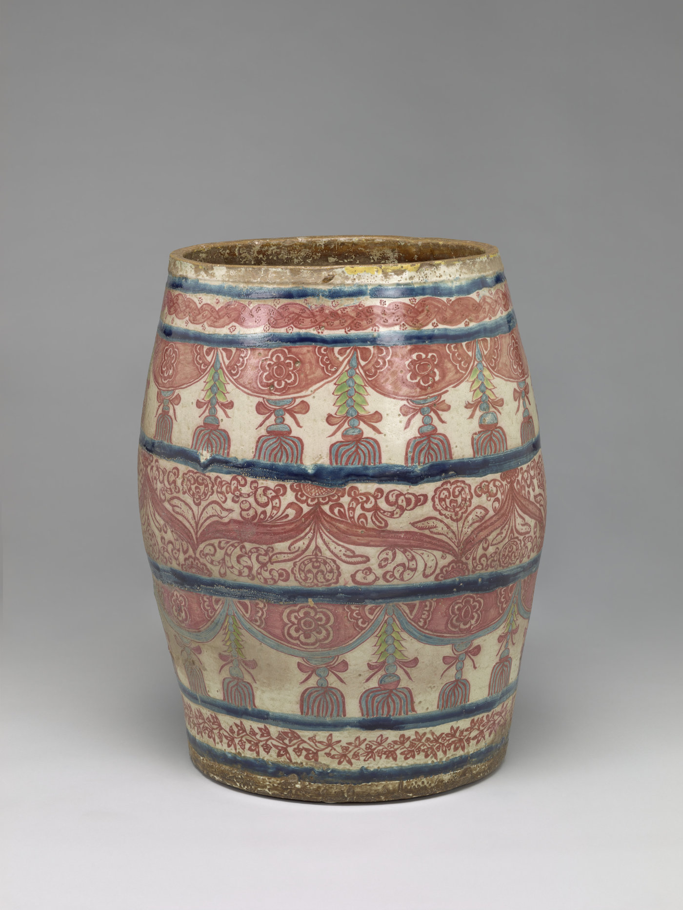 A vessel that bulges in the middle is divided into 7 registers and painted with red floral motifs.