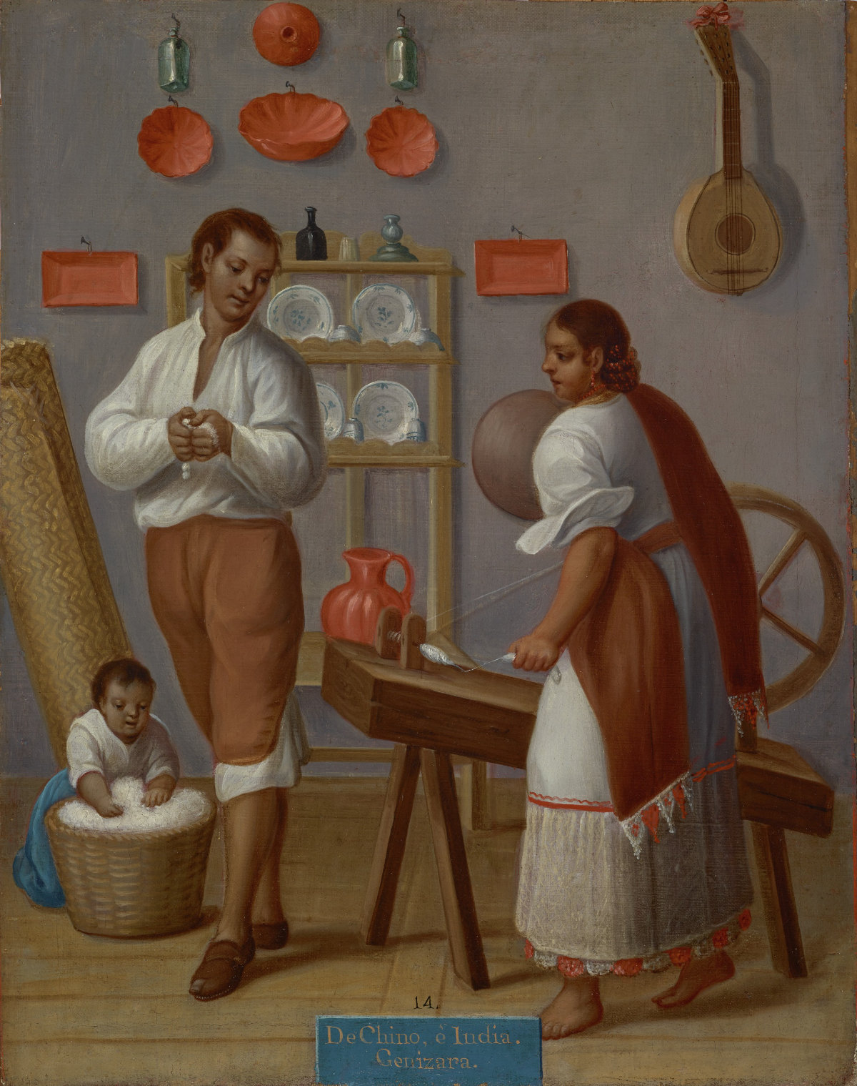 A man and woman in white and brown clothing stand near a weaving machine against a wall decorated with plates and an instrument. A small child kneels over a basket filled with white, fluffy material.